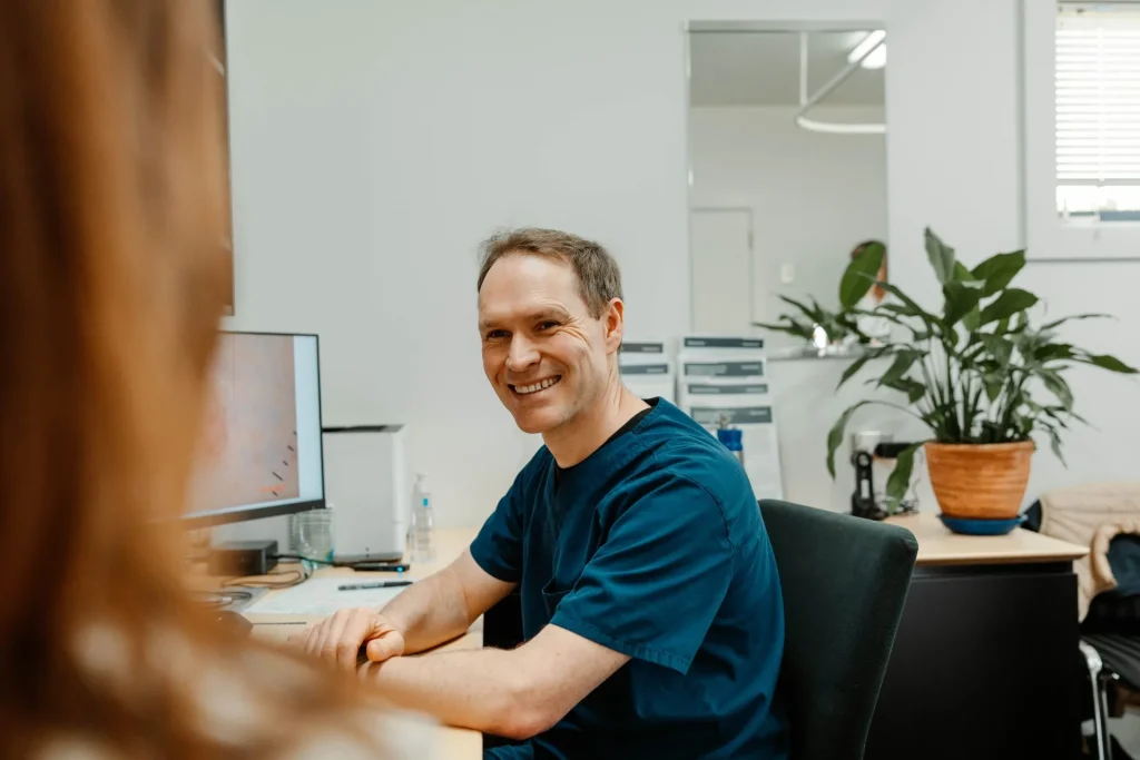 Doctor smiling at patient while sitting at his desk