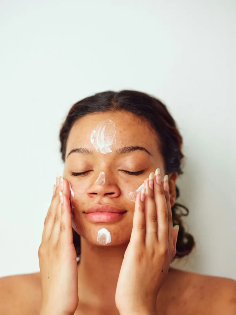 woman putting sunscreen on her face