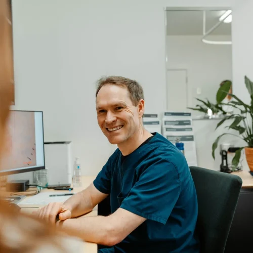 Doctor smiling at patient while sitting at his desk