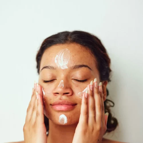 woman putting sunscreen on her face